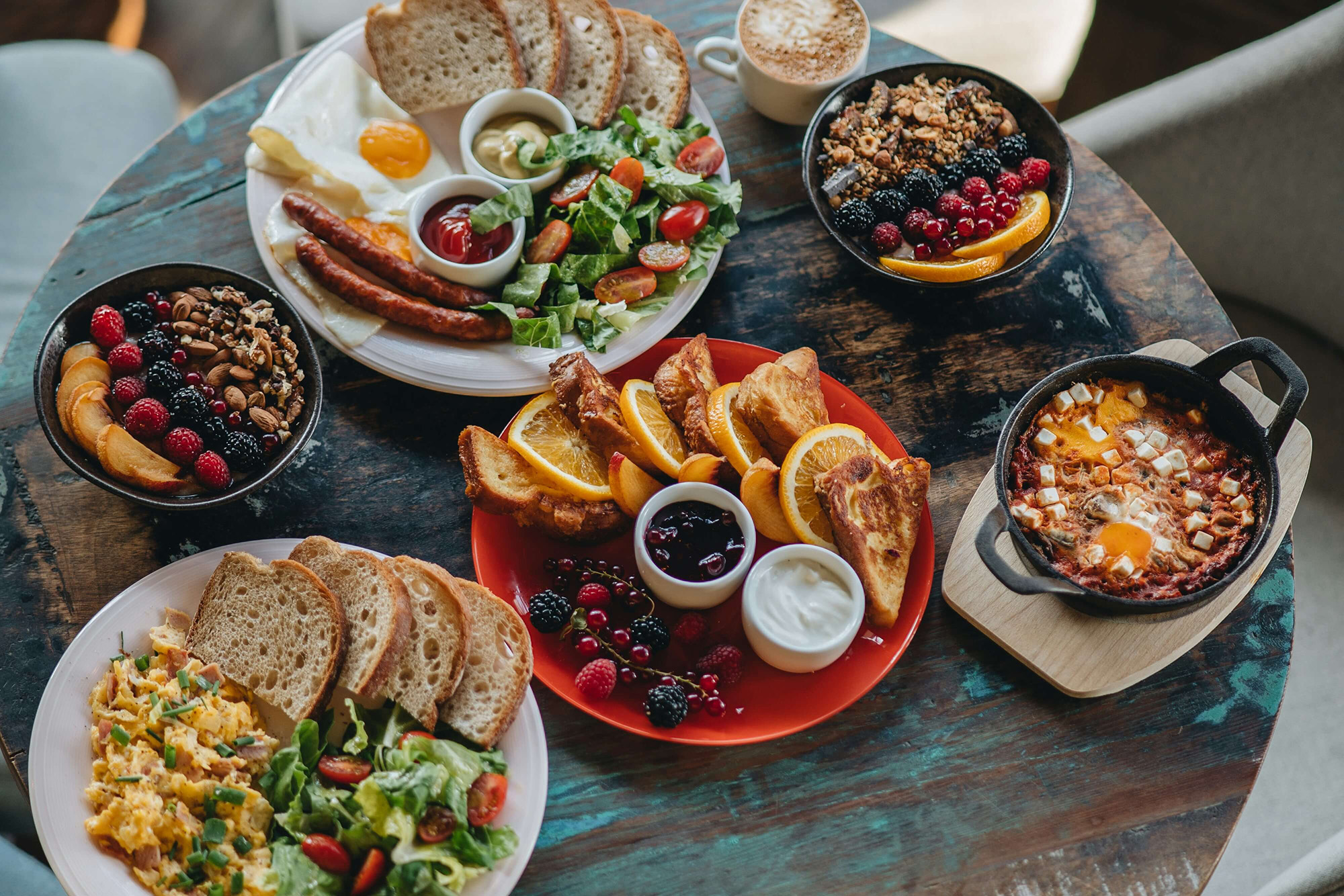 table with bread, jams and salads